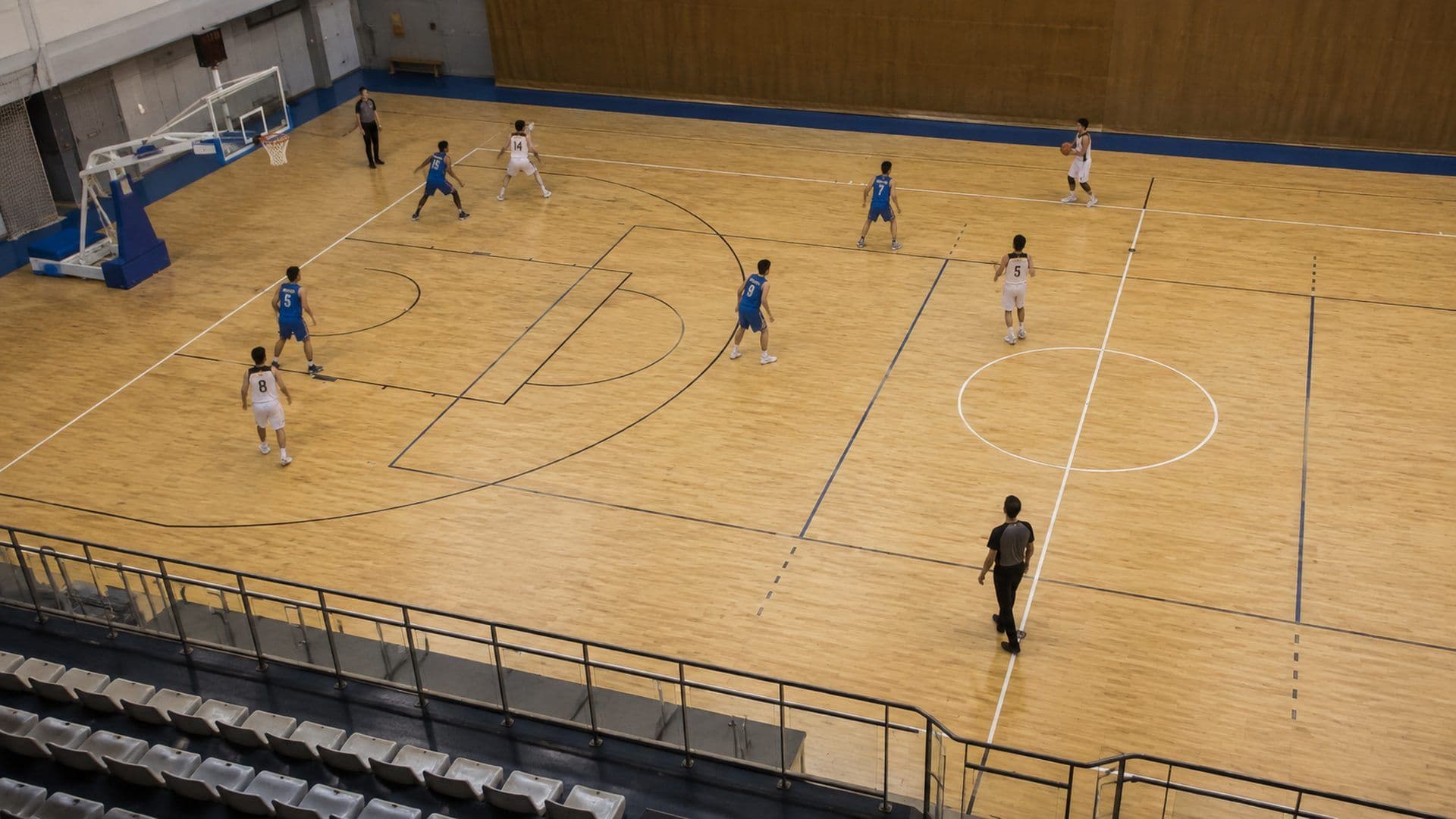 Vista de cima de meio-campo de basquetebol com os jogadores bem espaçados